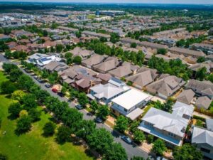 Aerial view of a residential neighborhood showing property boundaries and landscaped areas that may affect property line visibility.